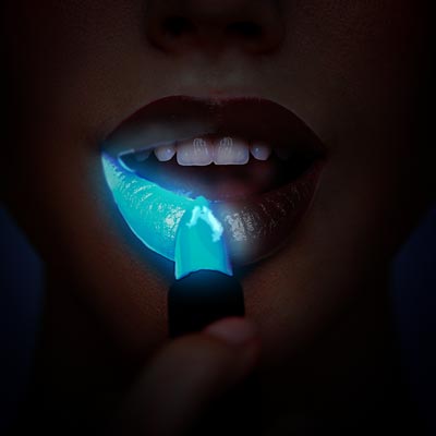 A concept of bioluminescent glowing lipstick being applied