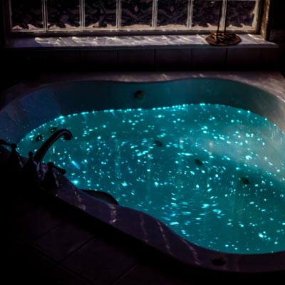 A bath tub glowing and sparkling with bioluminescent bath salts